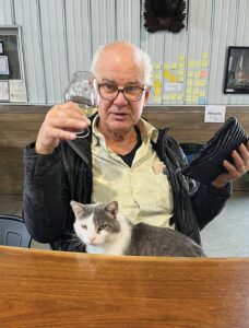 The late Morris Tammen enjoys a beer while hanging out with one of the several cats at the craft brewery that he and his family started at their centennial farm near Thawville. He died in February. Courtesy of Artesia Brewing