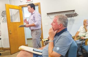 Attorney Adam Crutchley, background, speaks on behalf of his client, Justin Goss, as developer and former senator Bill Brady, foreground, looks on during Monday’s city council meeting. Mindy Basi/Ford County Chronicle